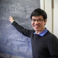 Zhanhong Jiang stands in front of a blackboard filled with mathematical equations, explaining the content.